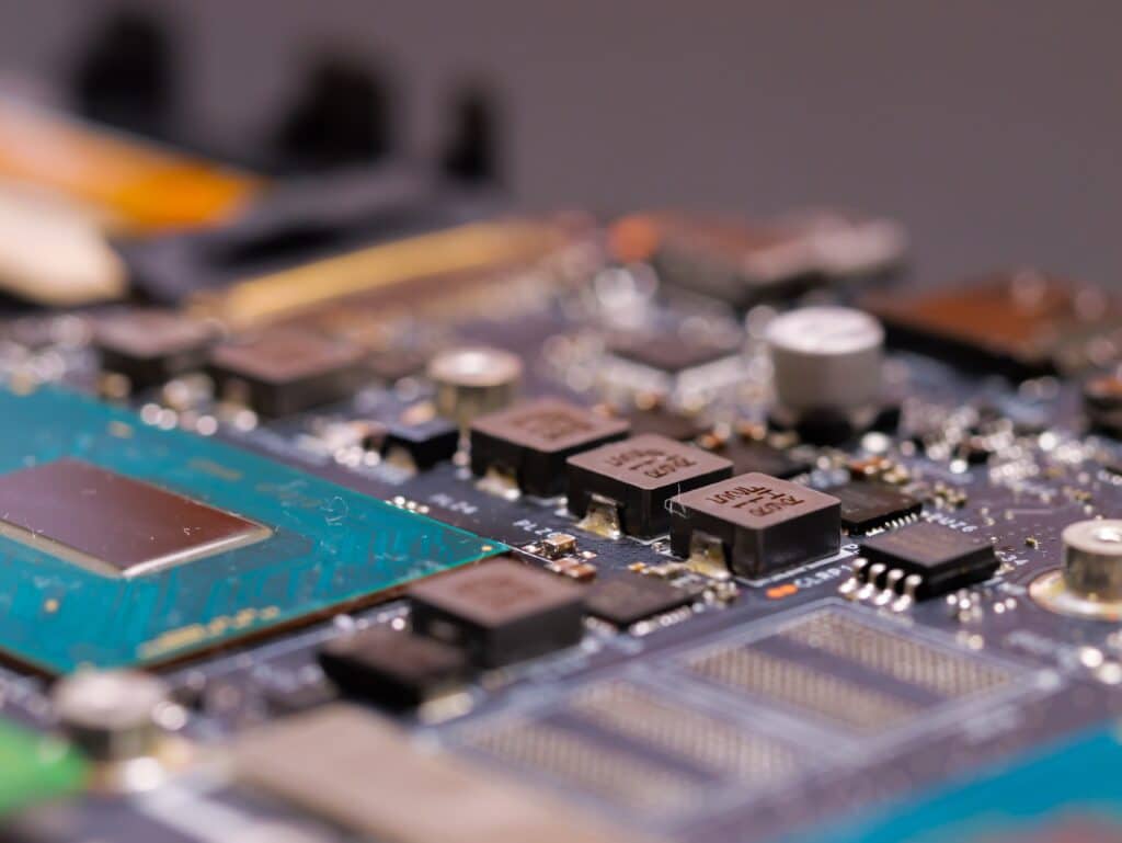 Carte mère : gros plan sur les composants et le processeur Gros plan d'une carte mère avec un processeur CPU entouré de condensateurs et circuits intégrés haute précision.