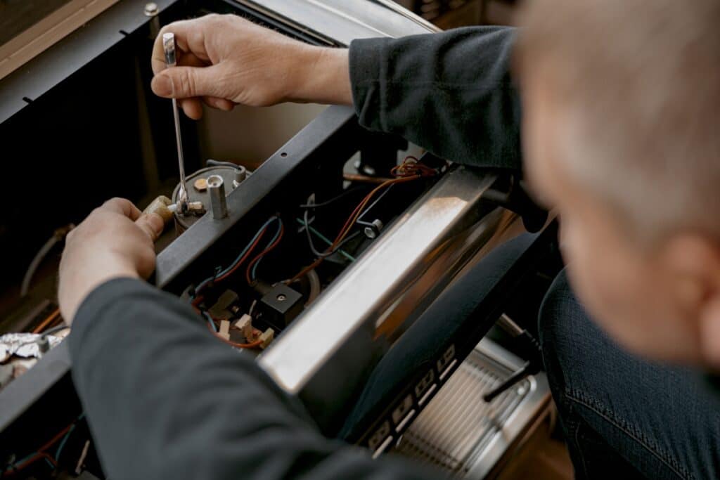 Réparation de Machine à Café : Service de Maintenance Technicien de maintenance réparant les composants internes d'une machine à café avec une clé professionnelle.